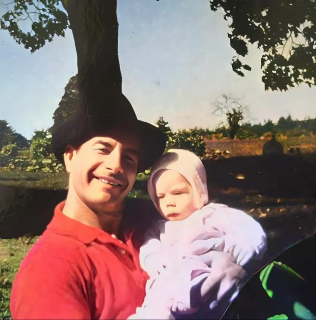 A man in a red t-shirt holding a baby